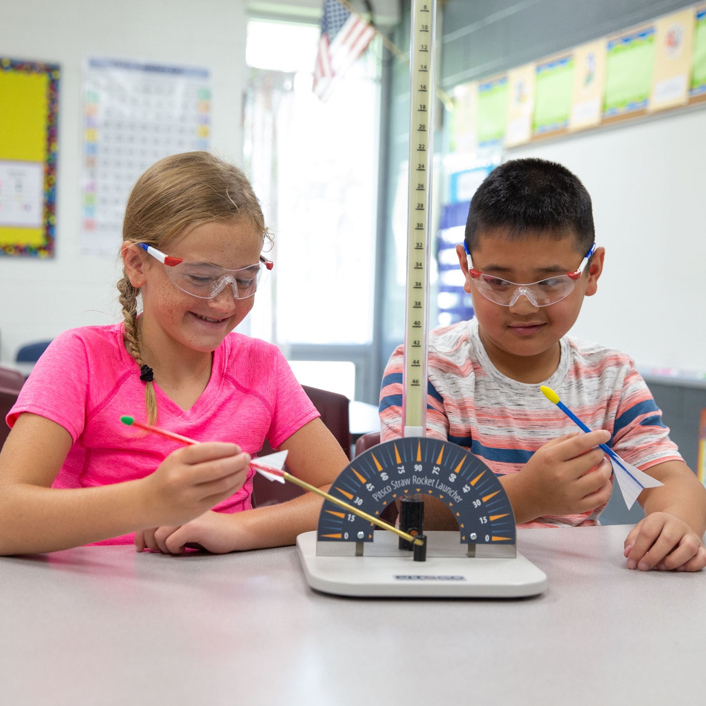 Two elementary students working together with Pitsco Education's straw rocket launcher to learn foundational STEM principals like force and motion.