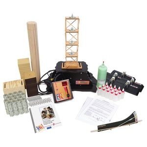 Balsa tower on a black shake table with controller, balsa sticks, glue bottles, weights, and project book