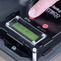 Digital display on a device with a person's finger pressing a button, featuring the brand 'Pitsco'.