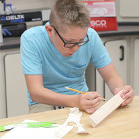 Middle school stuent fully engaged in his STEM project designing his CO2 dragster before the big race.