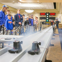 Students and coaches gathered around the G4 Impulse Race System to watch the finalists compete with their CO2 dragsters.