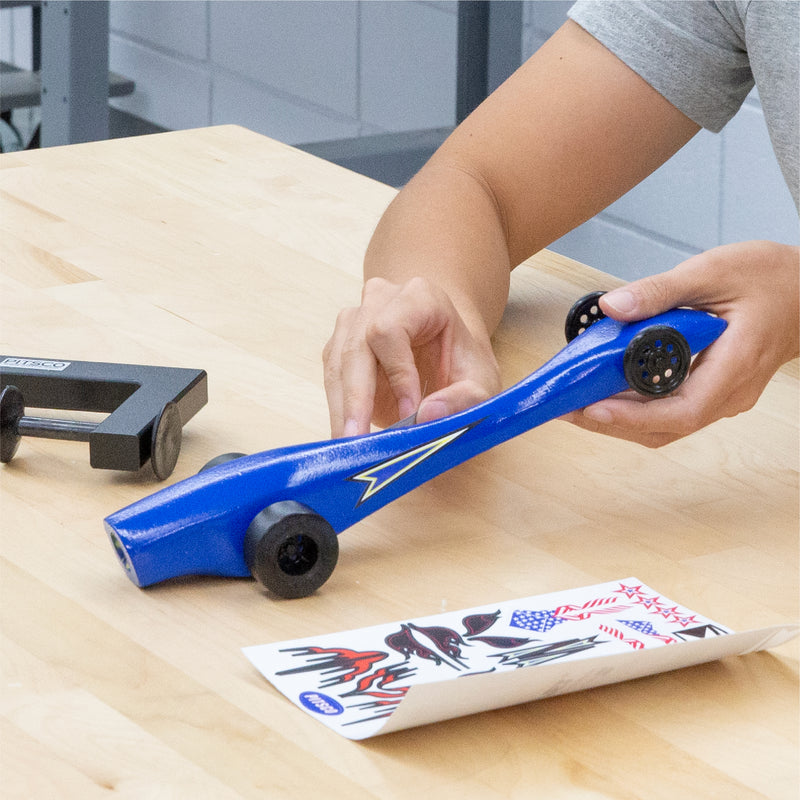 Student inspects and designs his CO2 dragster before race.