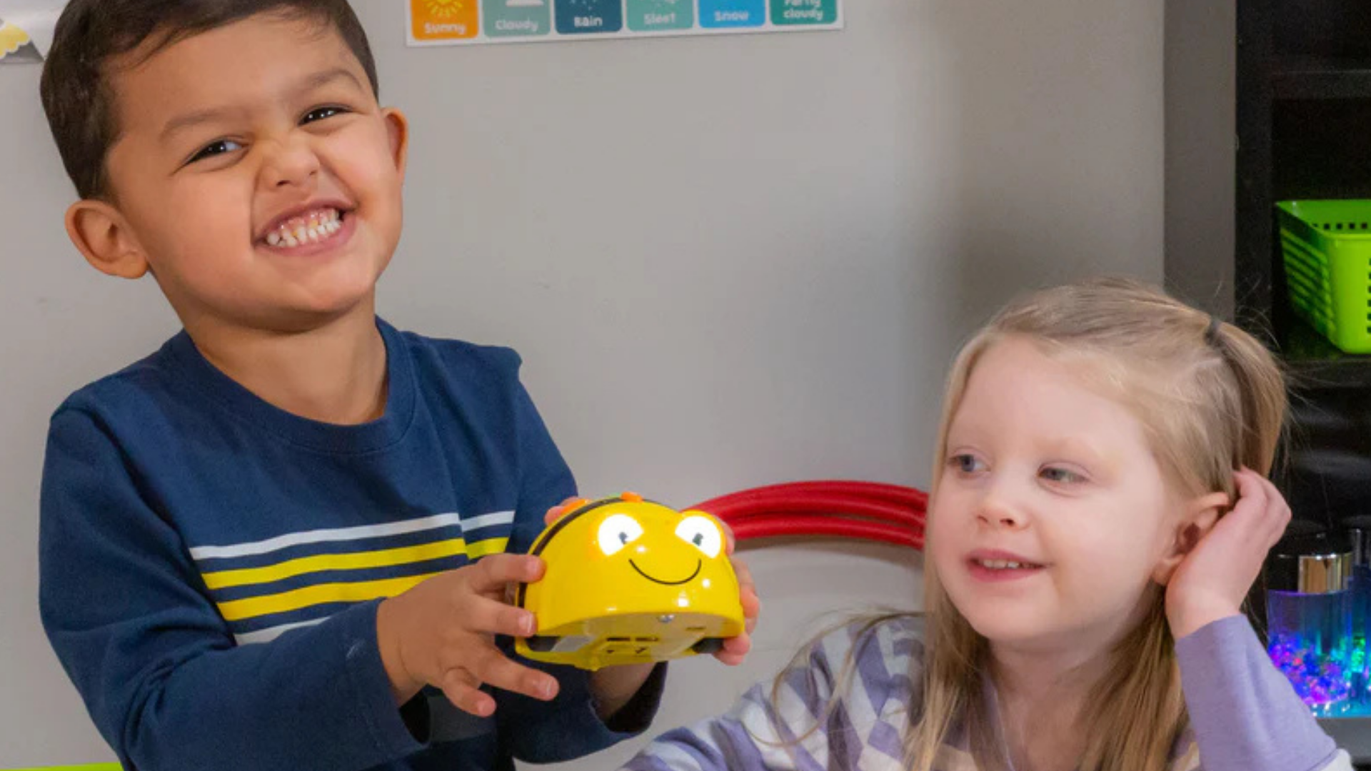 Young girl and boy student playing with Bee-Bot robot