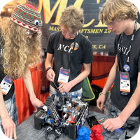 Three young students working on a TETRIX robot at a FIRST Tech Challenge competition