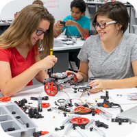 Two female students building a TETRIX PRIME robot with various components 