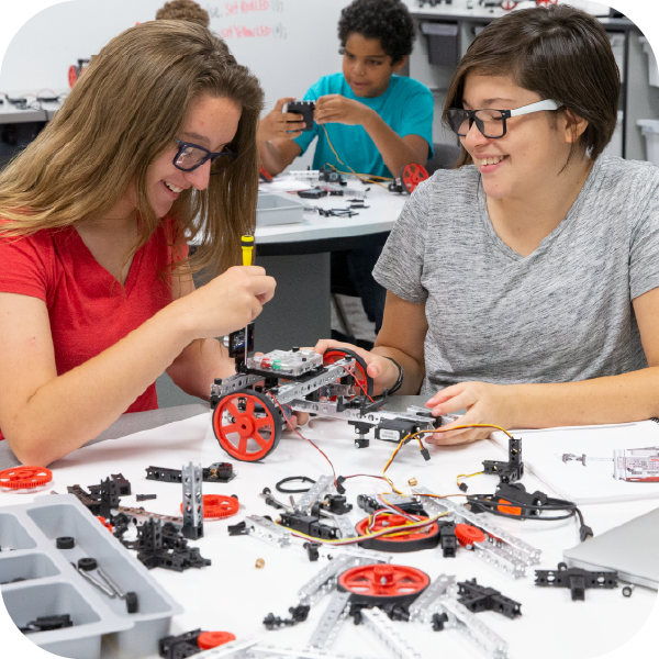 Two female students building a TETRIX PRIME robot with various components 