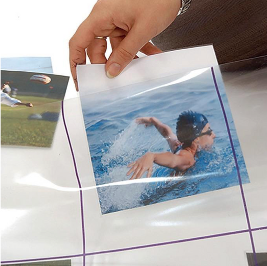 Hand holding a photo of a swimmer with a clear protective sheet over it